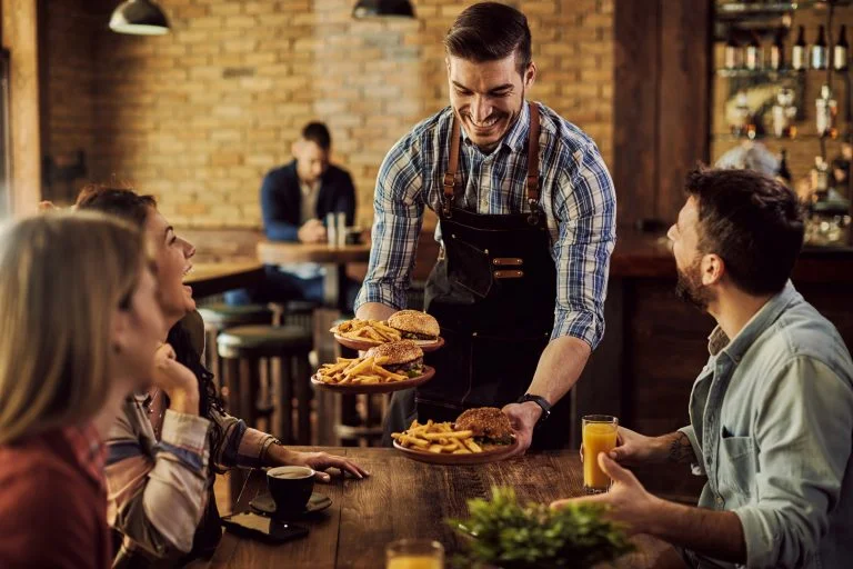 happy waiter serving food group cheerful friends pub 768x512 1