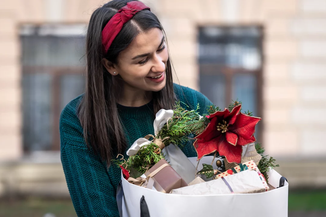 young woman with christmas gifts outside christmas shopping