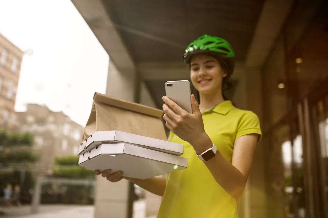 young woman yellow shirt delivering pizza using gadgets track order city s street courier using online app receiving payment tracking shipping address modern technologies 1
