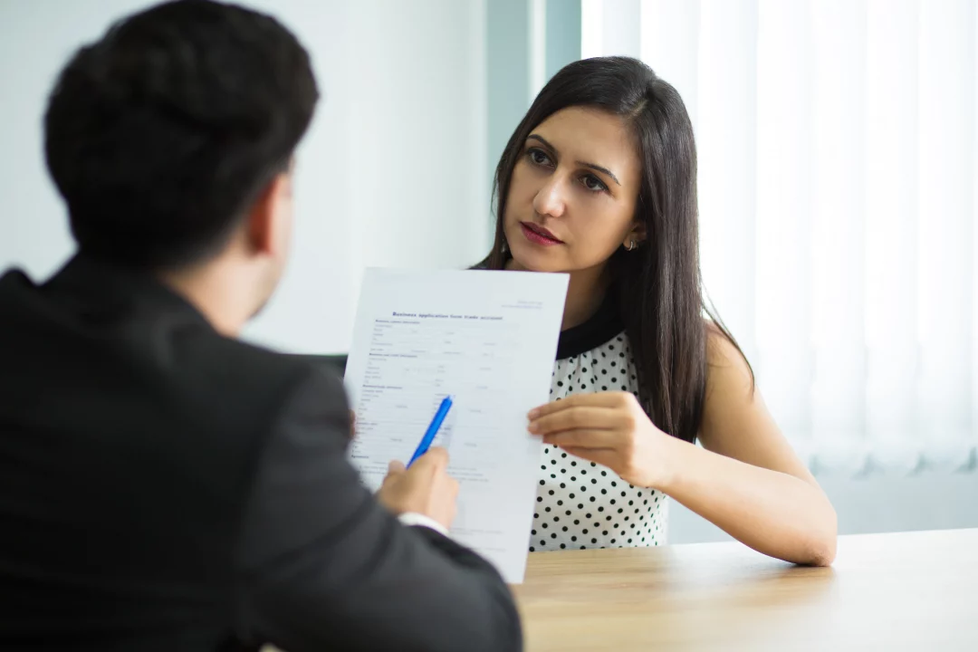 serious young female manager showing contract partner