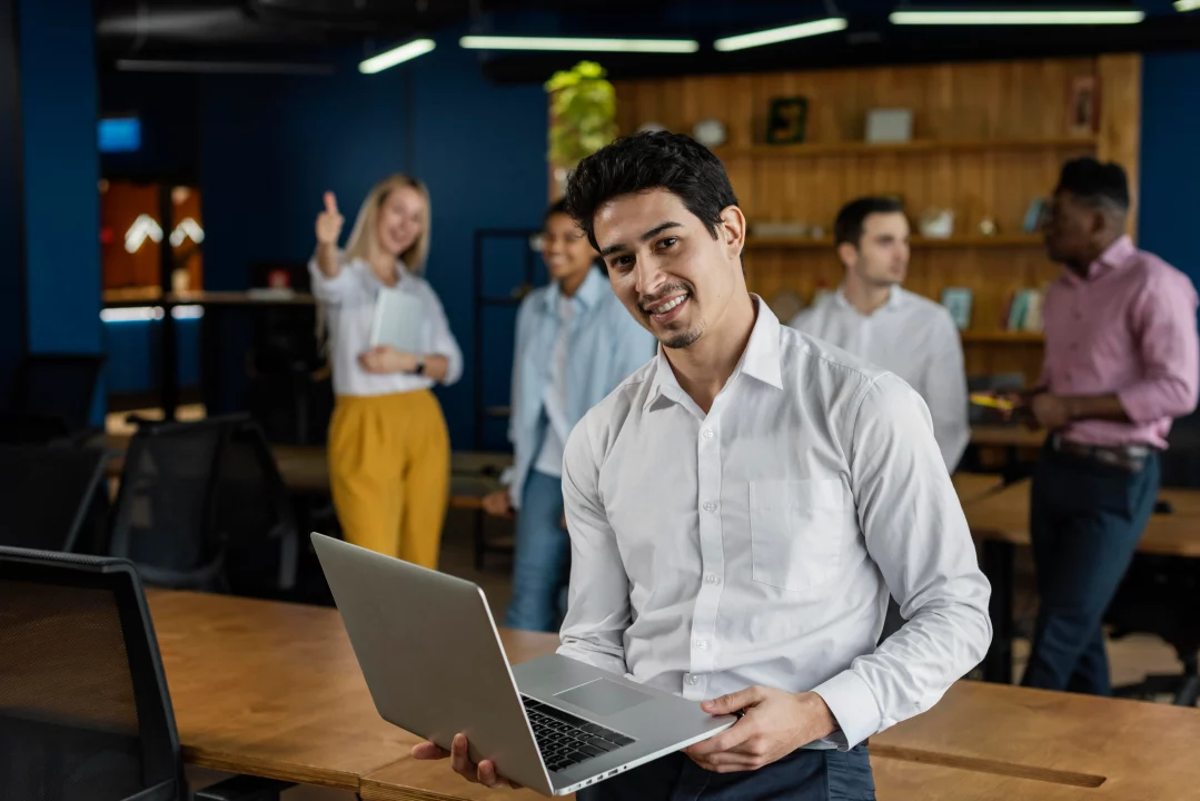 smiley man work holding laptop posing